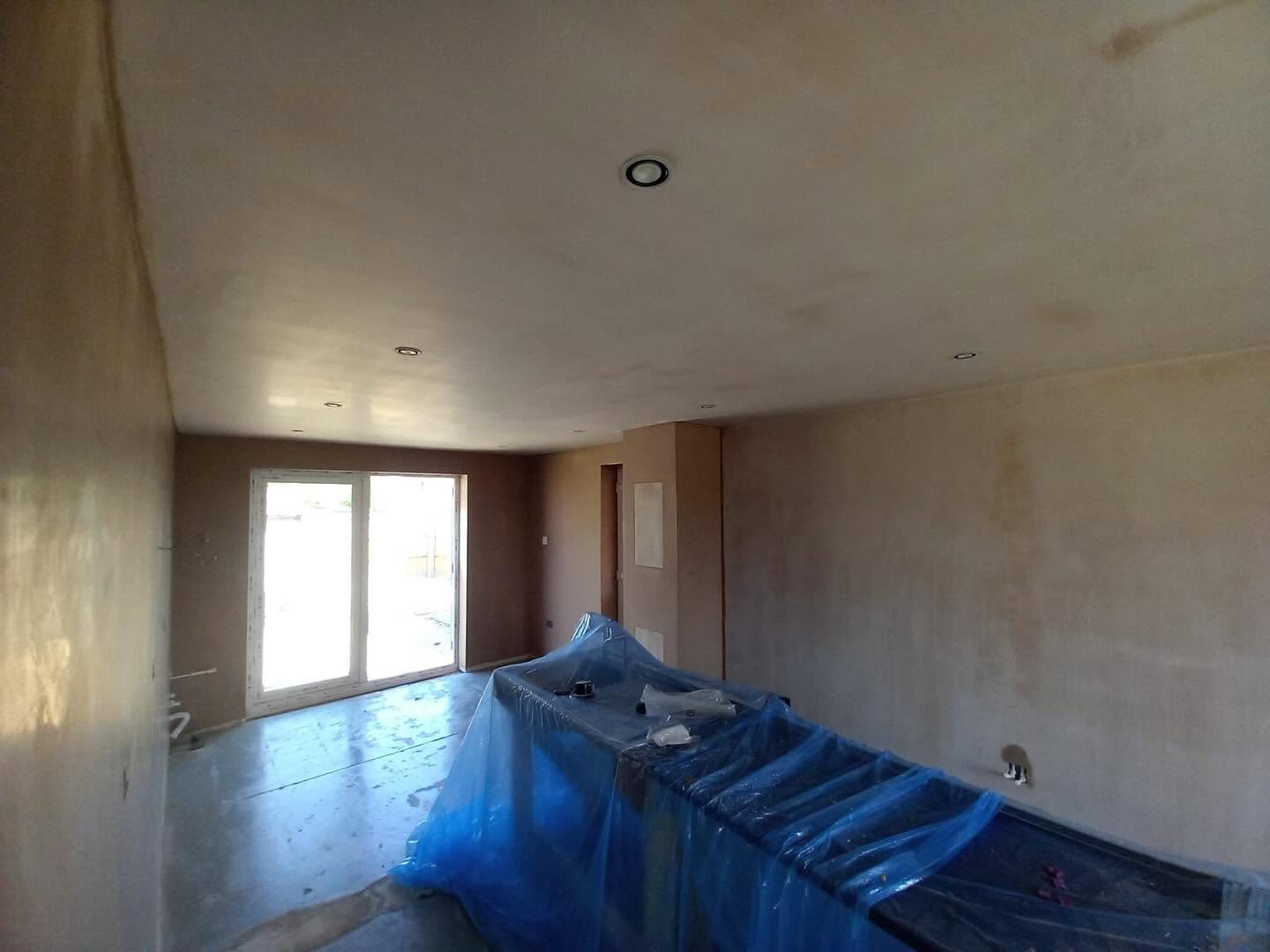 Open plan room mid-job, walls freshly skimmed