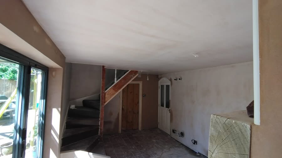 Open plan room with staircase, plastered and finished
