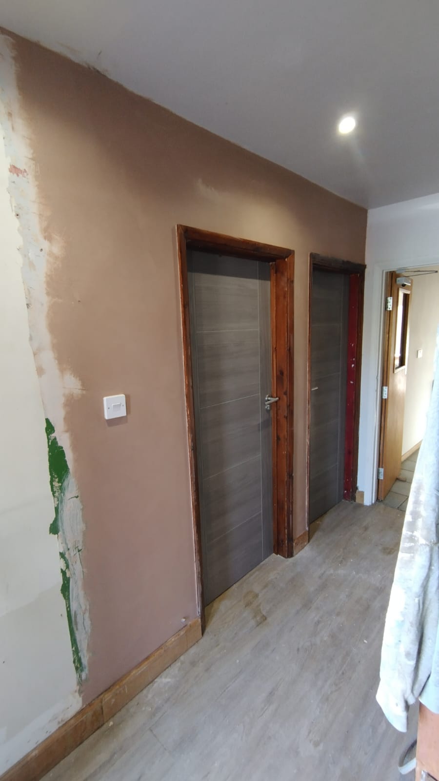 Hallway wall freshly skimmed beside new doors